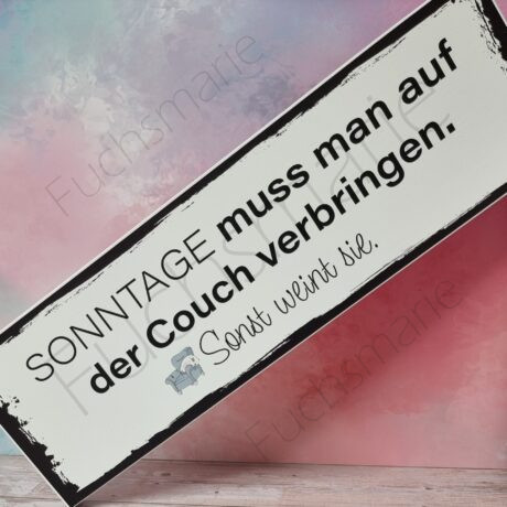 Holzschild mit Text: Sonntage muss man auf der Couch verbringen, sonst weint sie