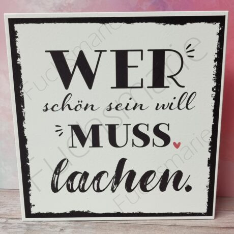 Holzschild mit Text: Wer schön sein will muss lachen