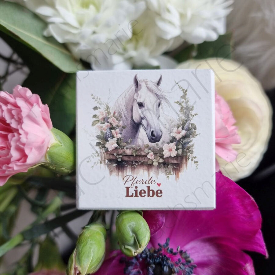 Magnet mit Pferdekopf. Weißes Pferd mit Blumenkranz.