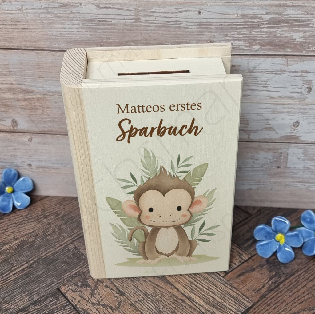 Sparbuch aus Holz Affe | 1 | 0542 Sparbuch Affe | Entdecke unser liebevoll gestaltetes Holz-Sparbuch – das perfekte Geschenk, um Kinder spielerisch an den Umgang mit Geld heranzuführen. Robust, charmant und lehrreich, begleitet es kleine Träumer auf ihrem Weg zu großen Zielen und vermittelt wichtige Werte wie Geduld und Verantwortung. Ein schönes Geschenk, das Freude und eine wertvolle Lektion fürs Leben schenkt! Sparbuch aus Holz mit Schloss zum Öffnen und Löwen Motiv