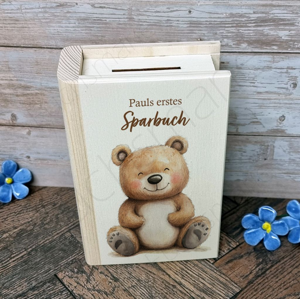 Sparbuch aus Holz Bär Bruno | 1 | 0545 Name Sparbuch Baer Bruno | Entdecke unser liebevoll gestaltetes Holz-Sparbuch – das perfekte Geschenk, um Kinder spielerisch an den Umgang mit Geld heranzuführen. Robust, charmant und lehrreich, begleitet es kleine Träumer auf ihrem Weg zu großen Zielen und vermittelt wichtige Werte wie Geduld und Verantwortung. Ein schönes Geschenk, das Freude und eine wertvolle Lektion fürs Leben schenkt! Sparbuch aus Holz mit Schloss zum Öffnen und Motiv Braunbär