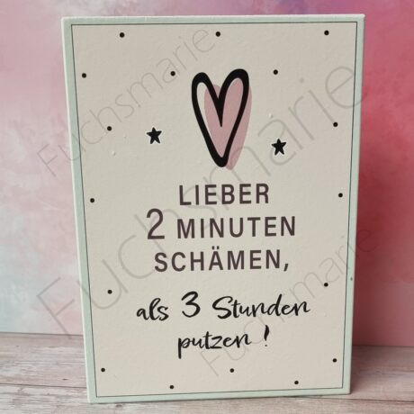 Holzschild mit Text: Lieber 2 Minuten schämen als 3 Stunden putzen